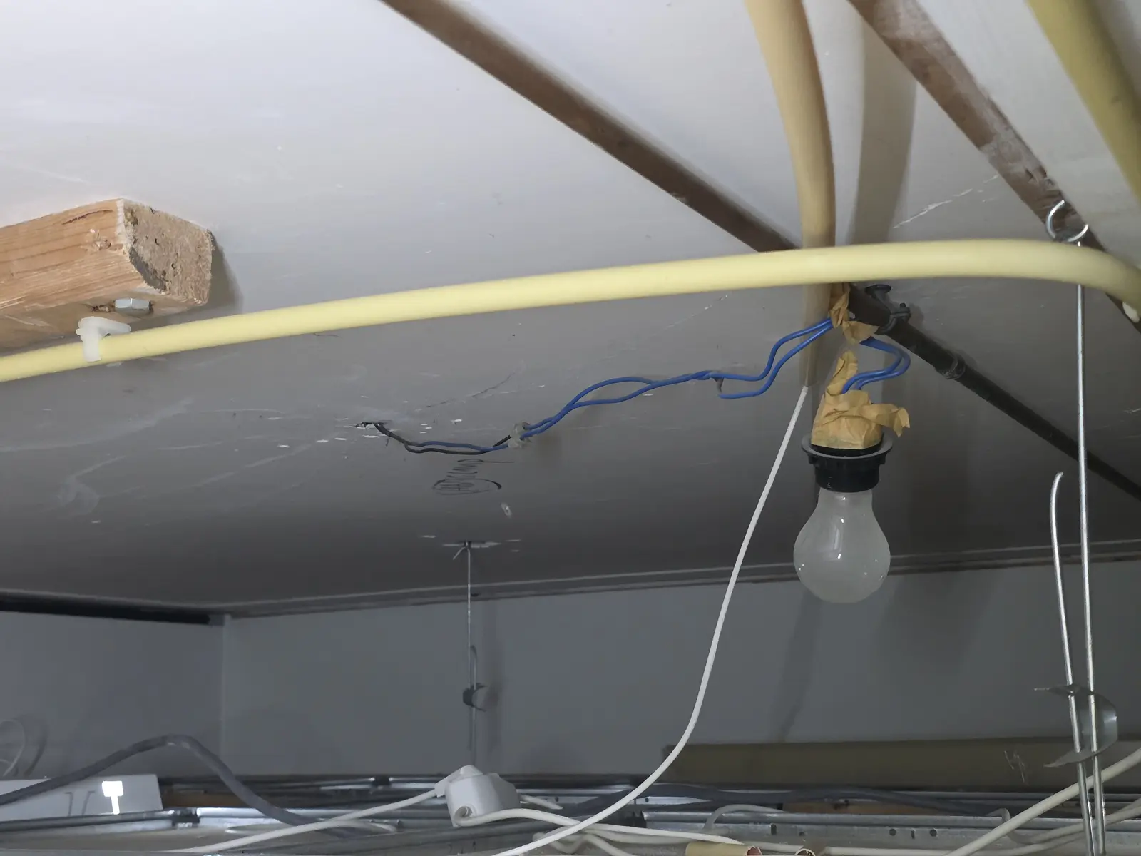 Oude verlichting boven een systeemplafond met open kroonsteen en tape