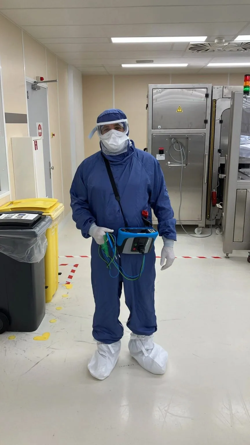 Inspecteur in volledige PPE tijdens een NEN 3140 keuring in een medische cleanroom