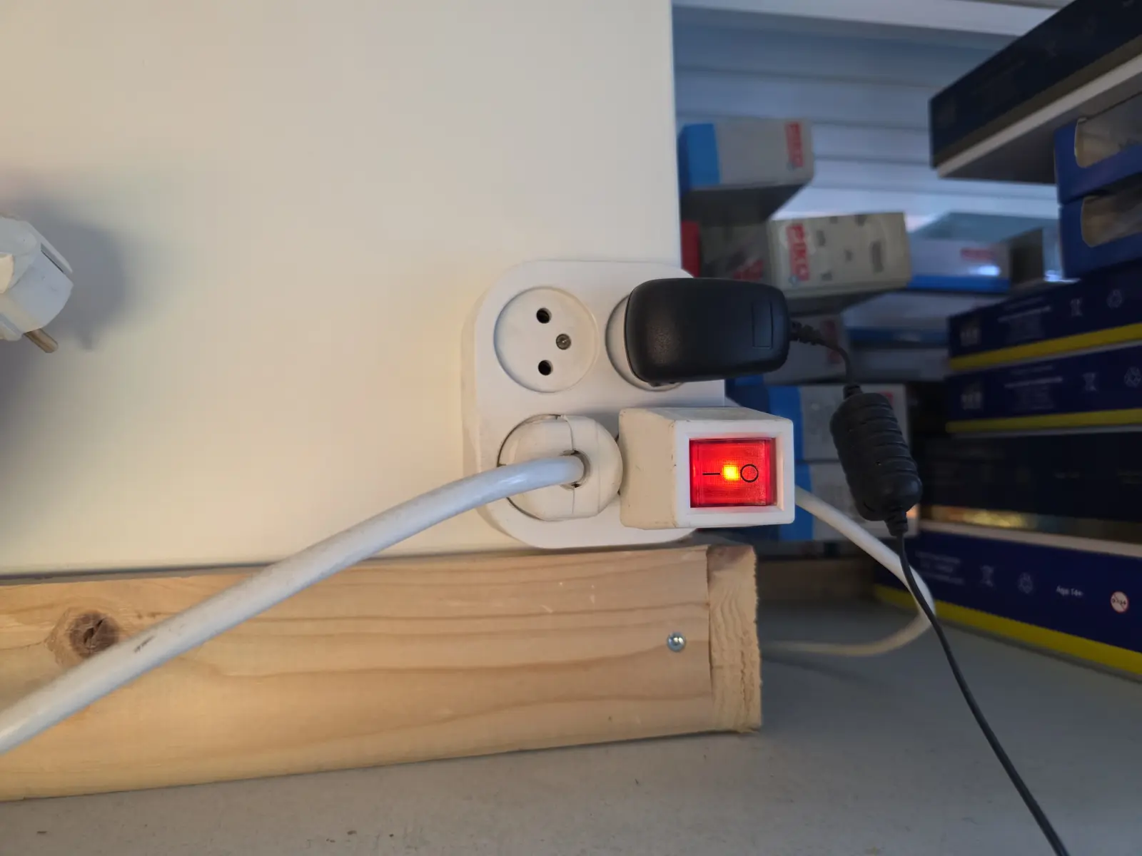 Opbouwwandcontactdoos op een houten regel met stekkerdoos